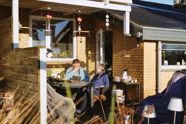 Par sidder på terassen og snakker