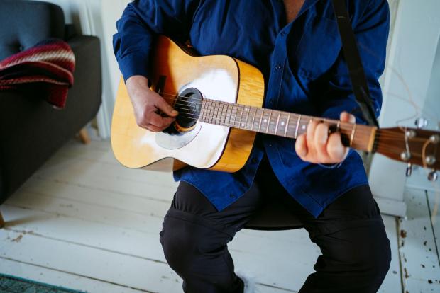 Nærbillede af mand der spiller guitar